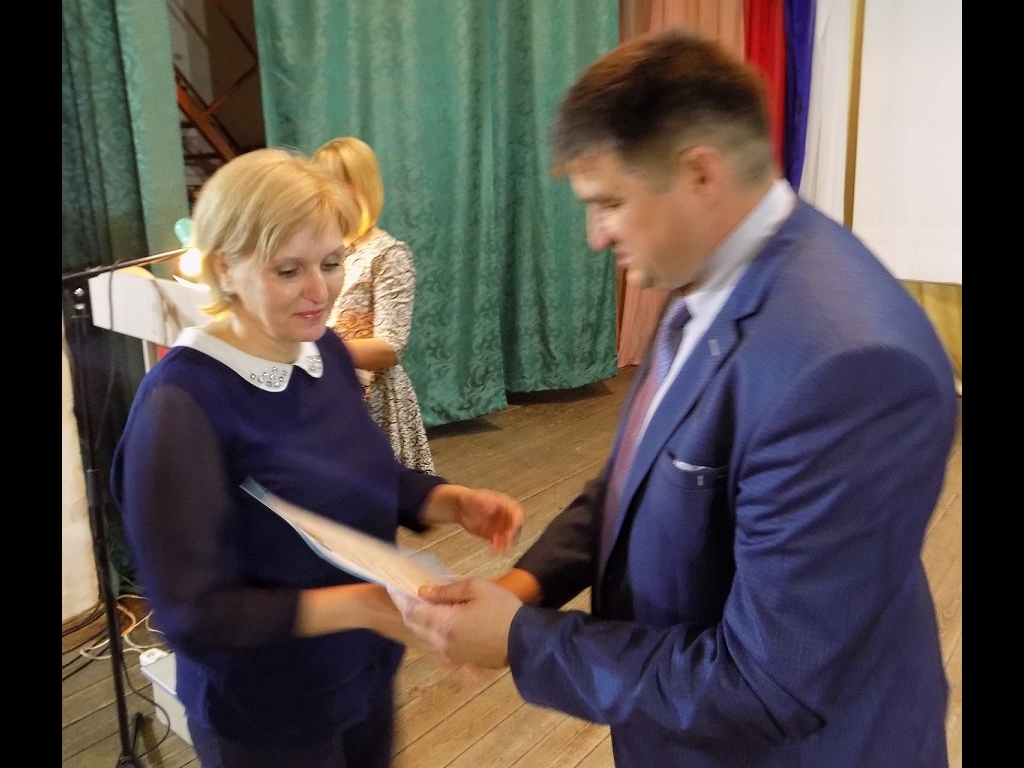 Глава администрации Льговского района С. Н. Коростелев вручает почетную грамоту ведущему специалисту отдела соцзащиты С. В. Фищенко
